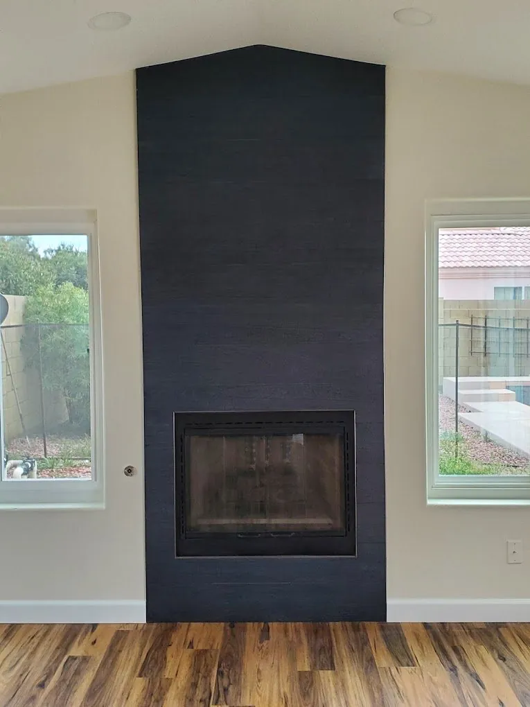 Floor to ceiling charcoal plank tile fireplace surround with wood look flooring Phoenix AZ