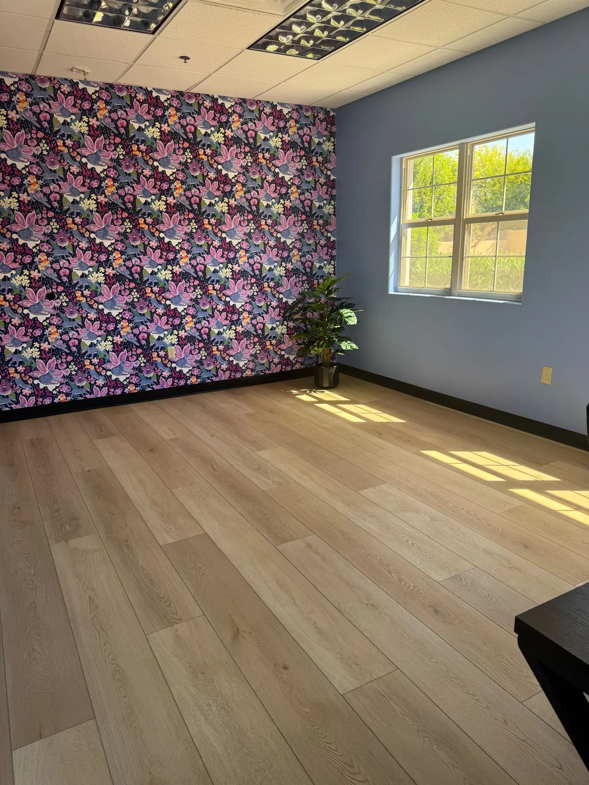 Commercial office with a floral feature wall and wood-look plank flooring installed by RDC Renovation in Phoenix AZ