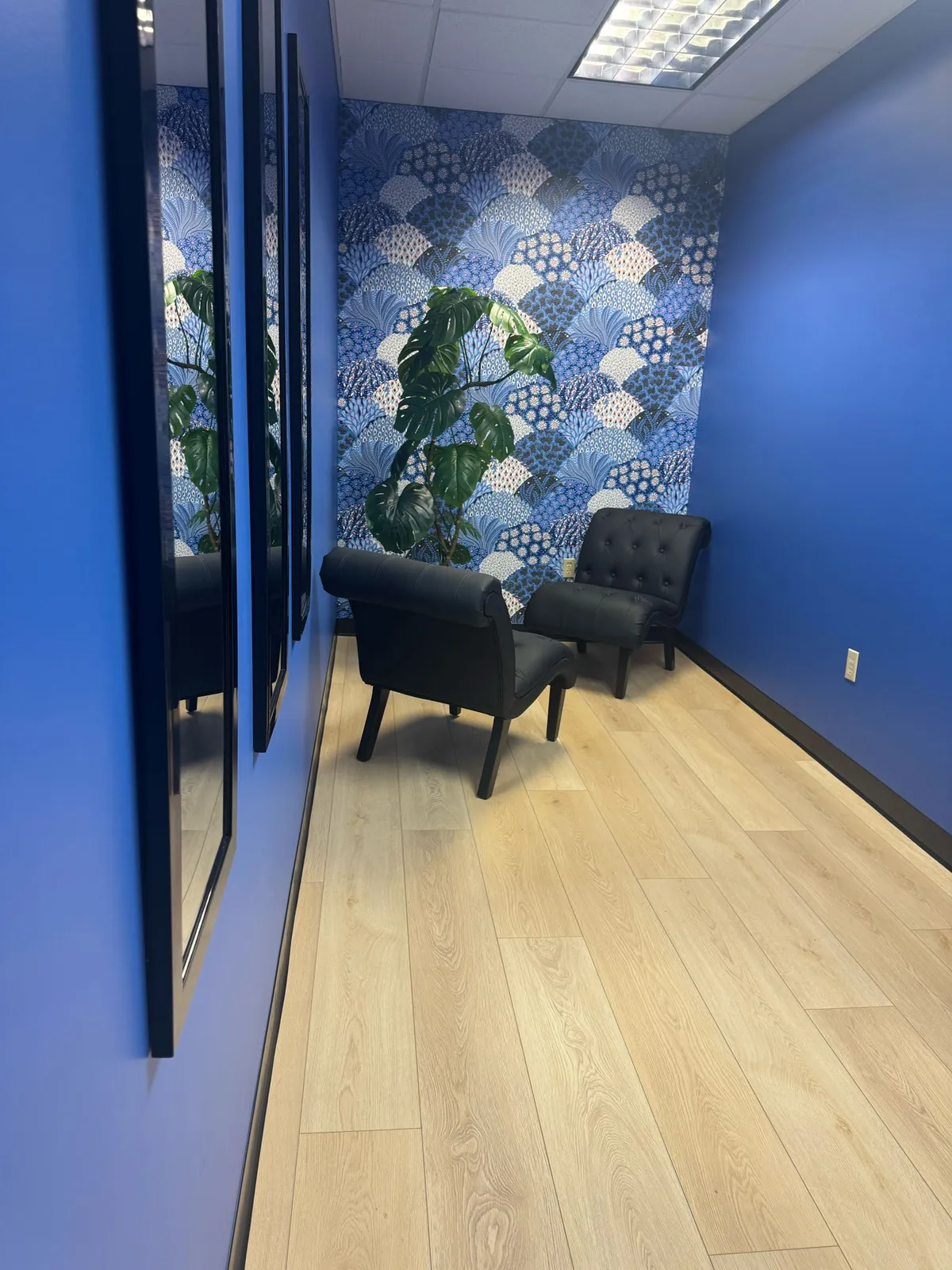 Commercial LVP flooring in an office waiting area with a wallpapered feature wall, installed by RDC Renovation in Phoenix AZ