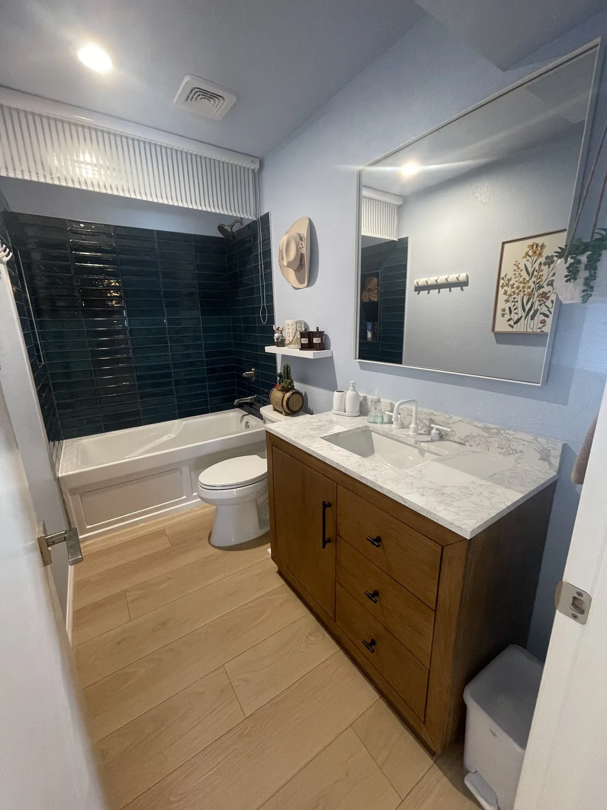 Dark green tile bathtub surround with wood vanity and marble-look top in a Phoenix AZ bathroom remodel by RDC Renovation