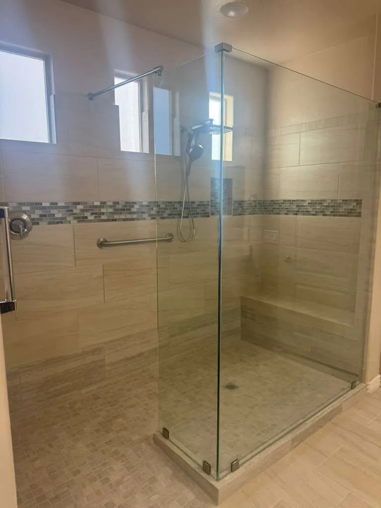 Glass walk-in shower with a mosaic accent band in a Phoenix AZ bathroom remodel by RDC Renovation