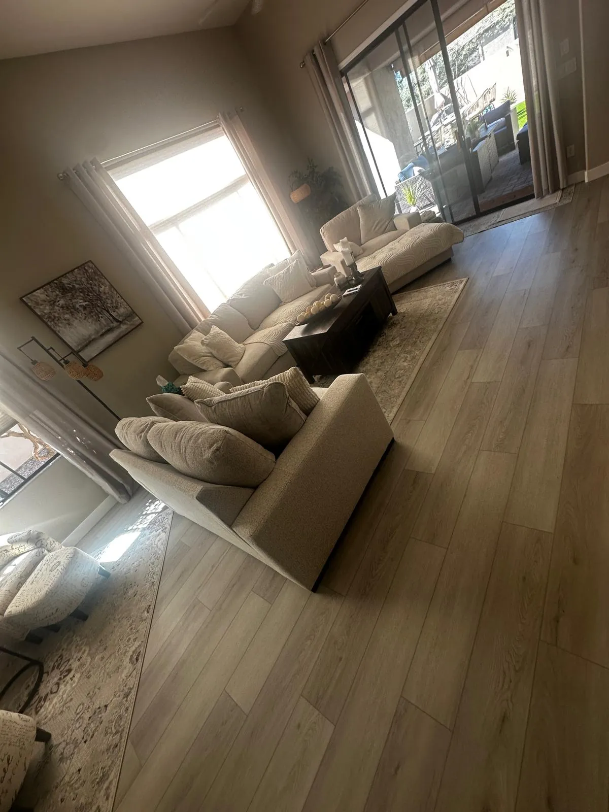 Gray wood-look plank flooring under the sofas of a Mesa, AZ living room, an RDC whole-home LVP job