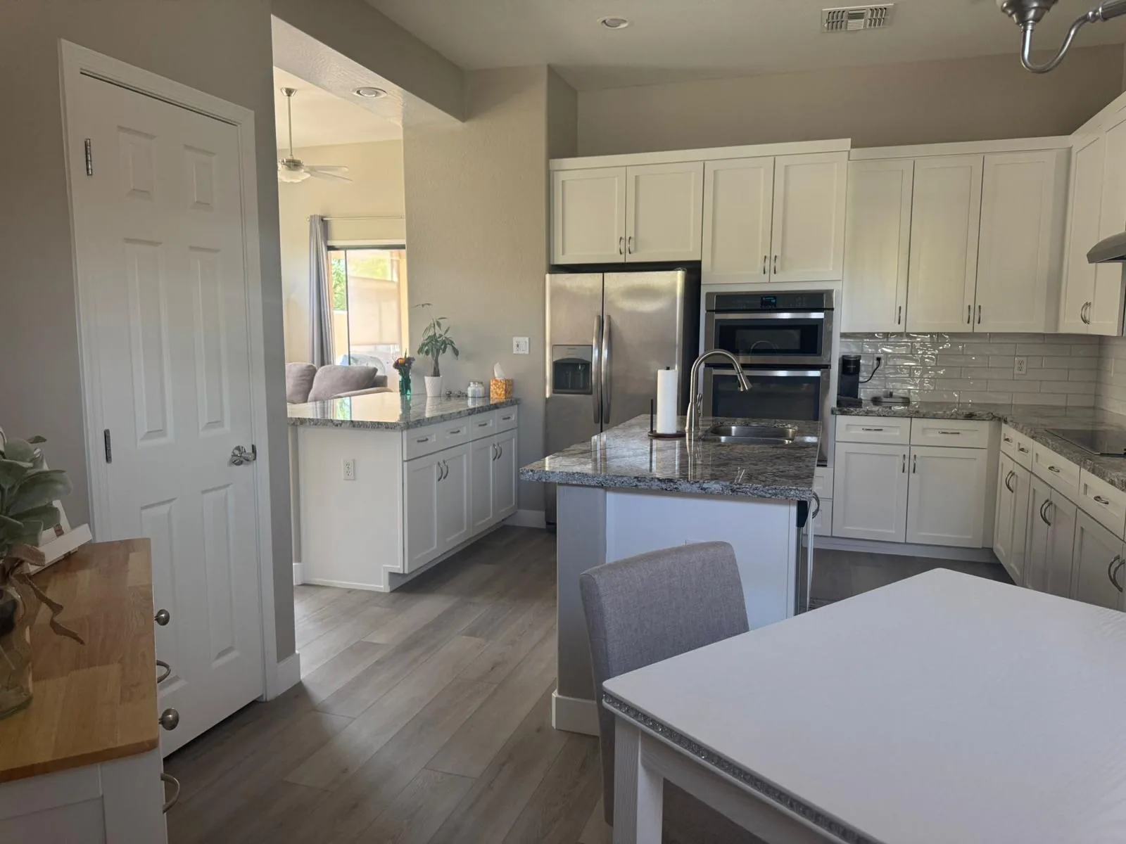 Gray wood-look LVP across a white Mesa, AZ kitchen, installed by RDC Renovation once the old tile was removed
