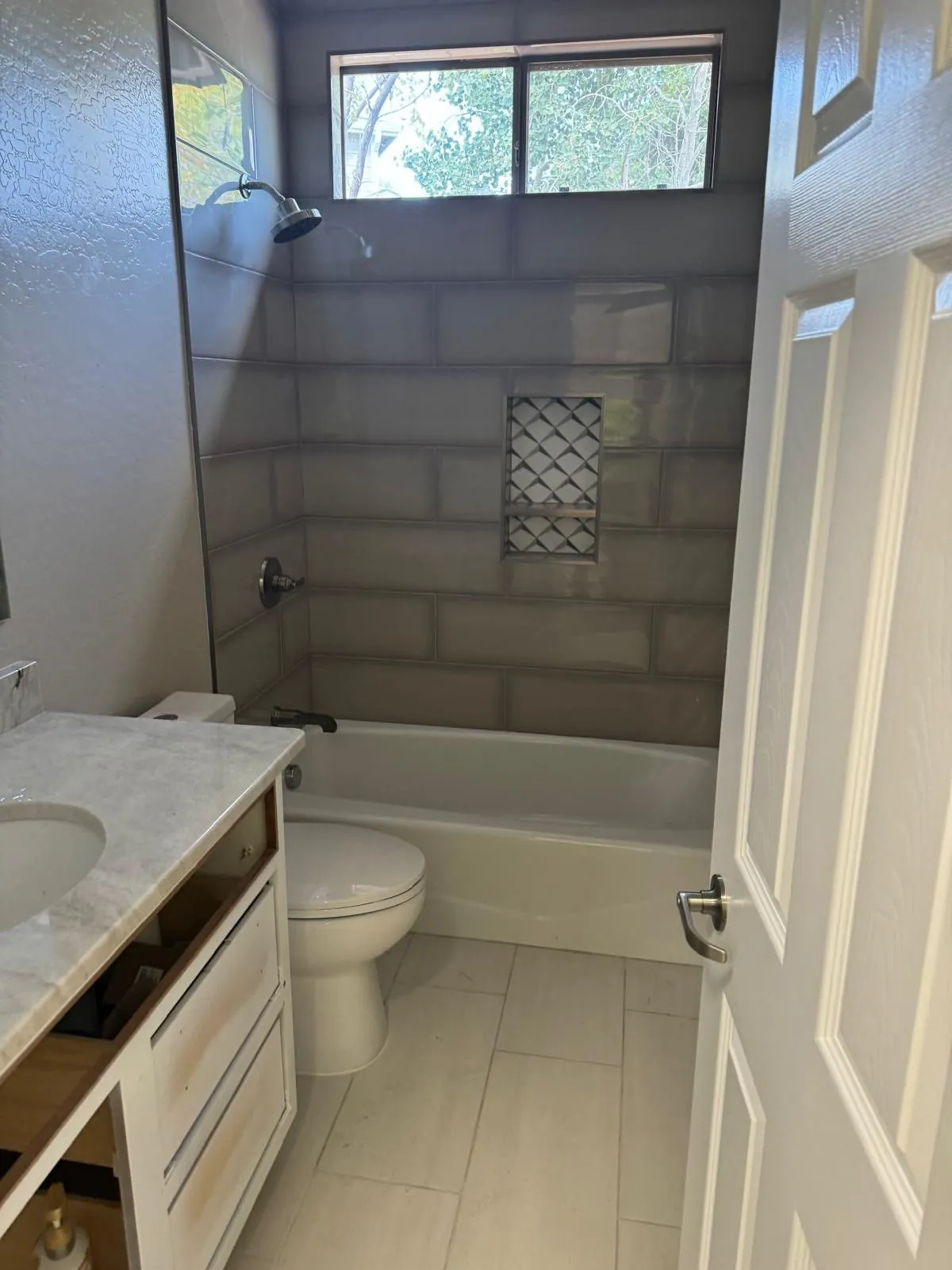 Gray subway tile tub and shower combo with marble look vanity top Phoenix AZ