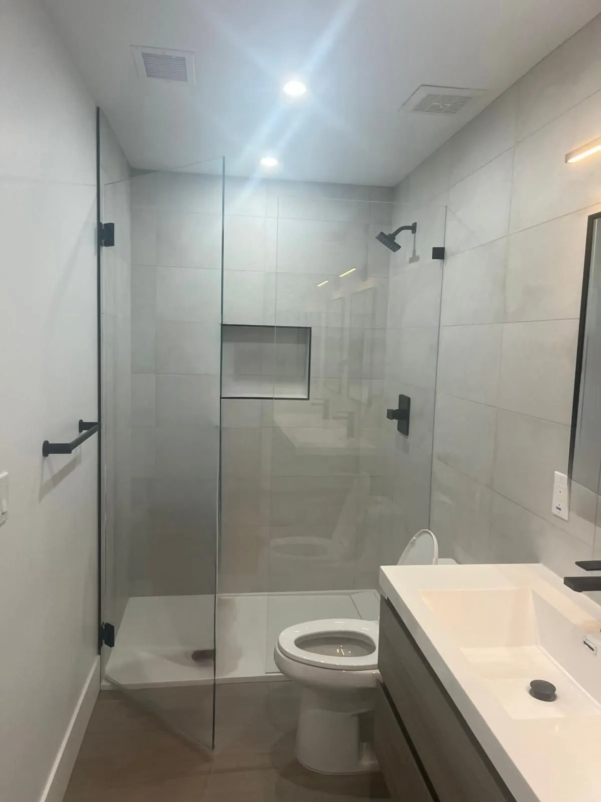 Modern gray large format tile shower with black fixtures and floating vanity Phoenix AZ