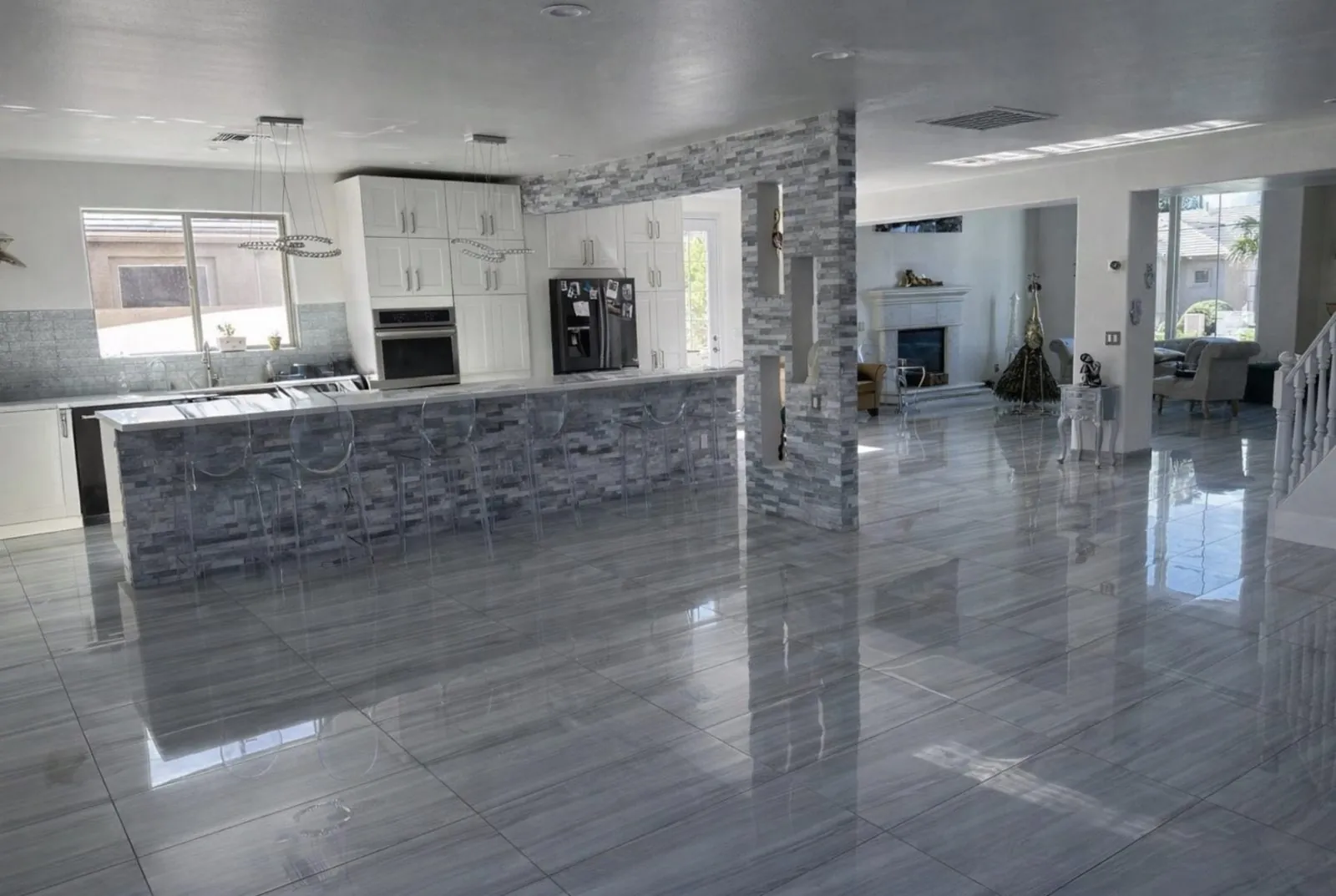 Large format polished gray porcelain tile floor installation in open concept kitchen and living room Phoenix AZ