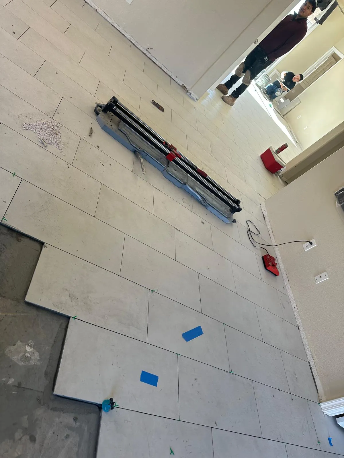 Large format tile being installed with a leveling system over a prepared slab by RDC Renovation in Phoenix AZ