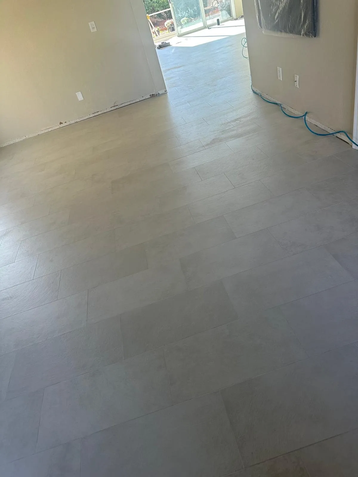 Light gray large format tile flooring installation in open living room Phoenix AZ