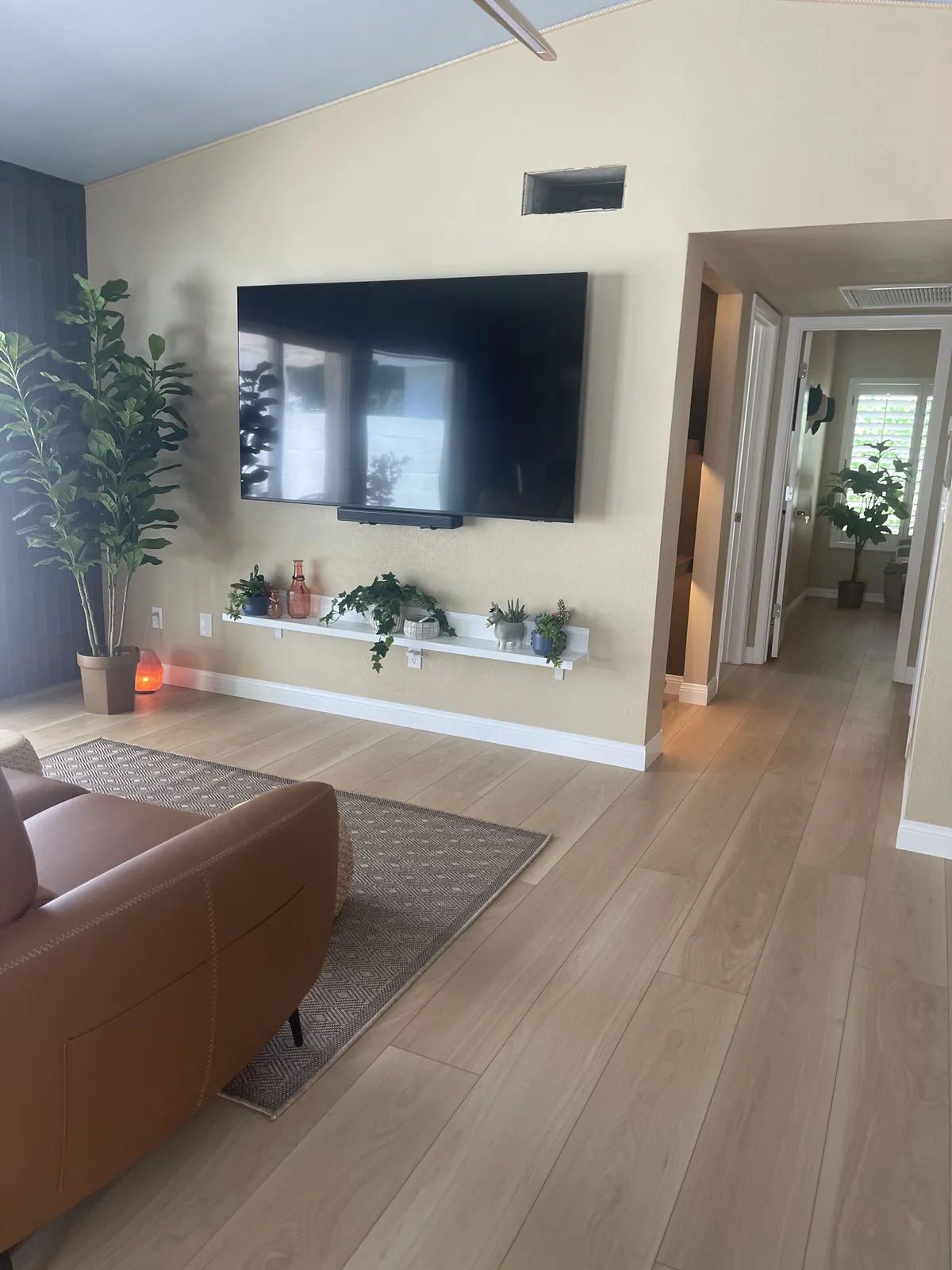 Light LVP flooring in a remodeled living room with TV wall in Phoenix AZ by RDC Renovation
