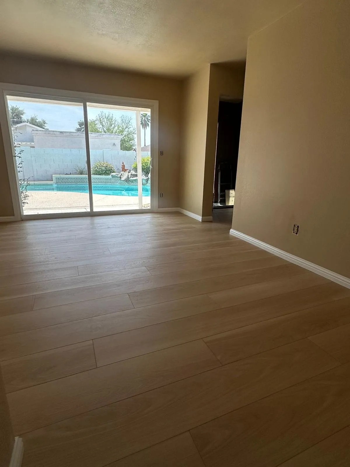 Light wood look LVP flooring in room with sliding door to backyard pool Phoenix AZ
