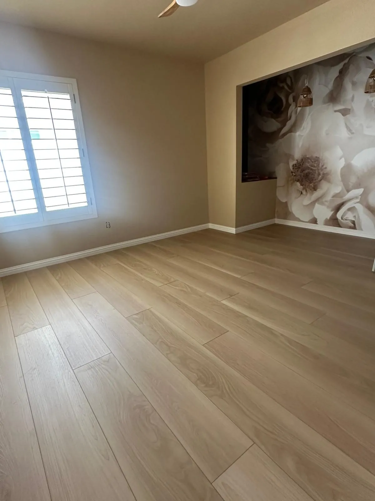 Wide plank LVP flooring installation in bedroom with floral mural accent wall Phoenix AZ
