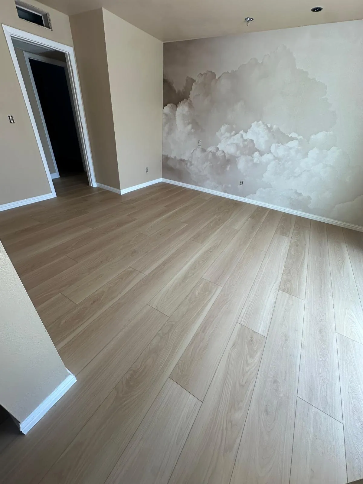 Light LVP flooring in living room with cloud mural accent wall Phoenix AZ