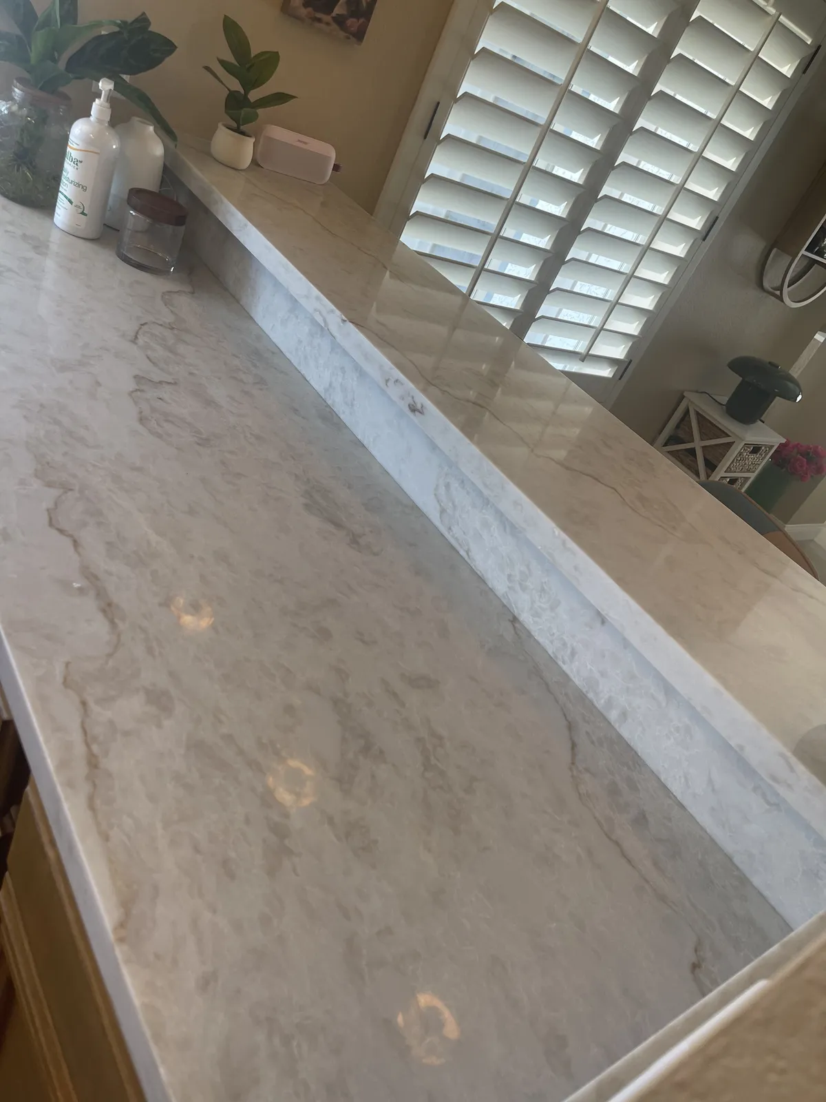 Marble look countertop detail with plantation shutters in a Phoenix AZ remodel by RDC Renovation