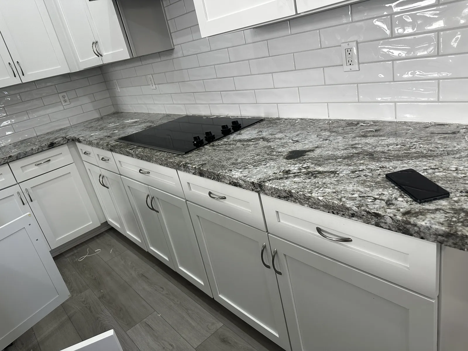 Old speckled granite on white cabinets in a Mesa, AZ kitchen before countertop replacement by RDC Renovation