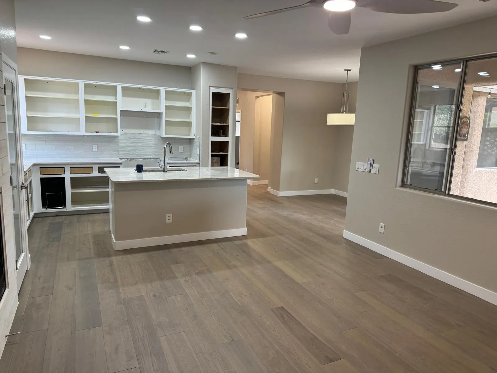 Wood flooring flowing through open concept kitchen and living area mid-renovation Phoenix AZ