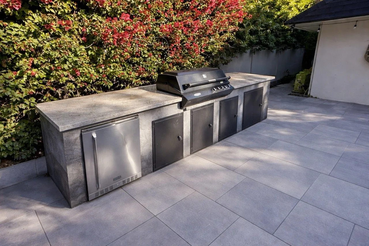 Outdoor kitchen BBQ area with large format gray porcelain tile patio and concrete countertops Phoenix AZ