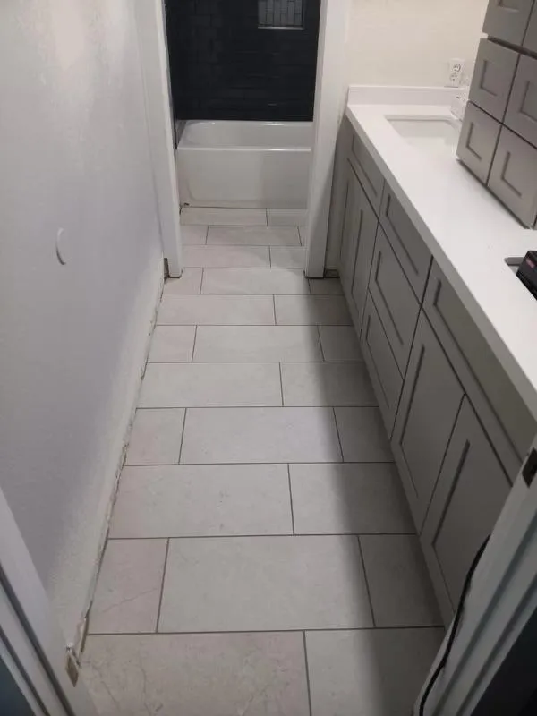 Tile flooring in a bathroom with a gray vanity installed by RDC Renovation, serving Sun City AZ