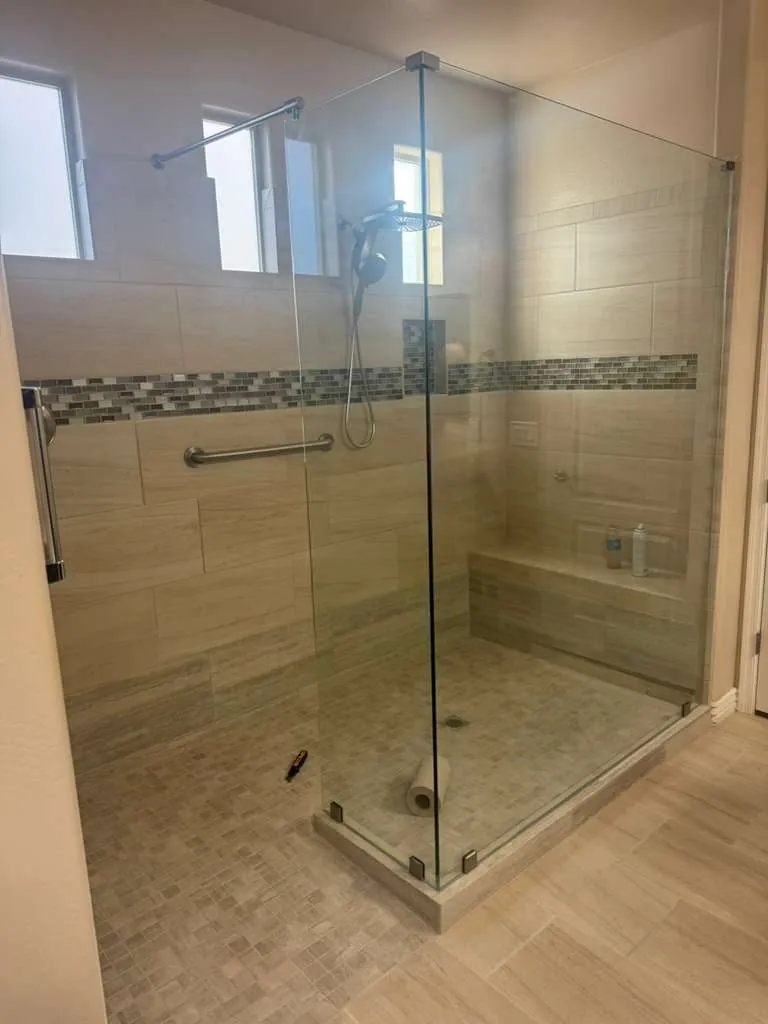 Walk-in frameless glass shower with mosaic glass accent band bench seat and rain shower head Phoenix AZ