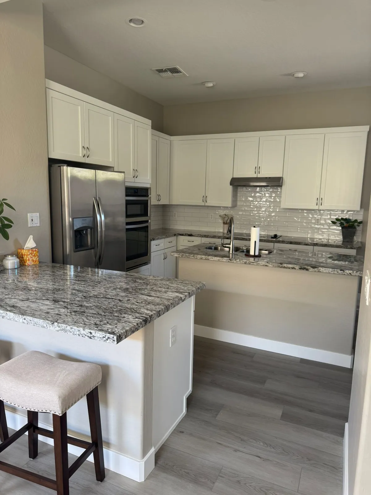 White kitchen with granite counters and a tile backsplash remodeled by RDC Renovation in Phoenix AZ