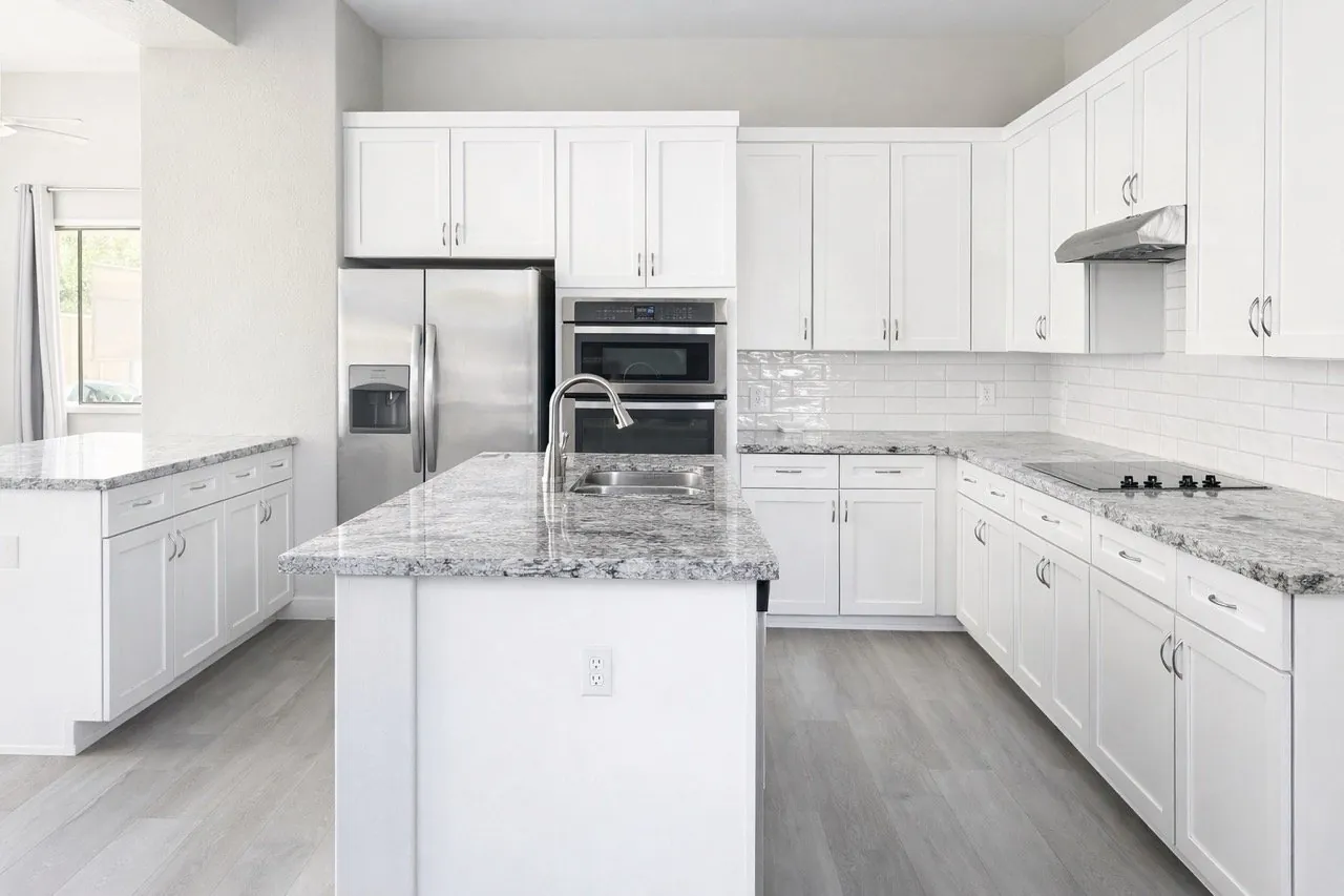 White kitchen remodel with granite countertops subway tile backsplash stainless appliances and LVP flooring Phoenix AZ