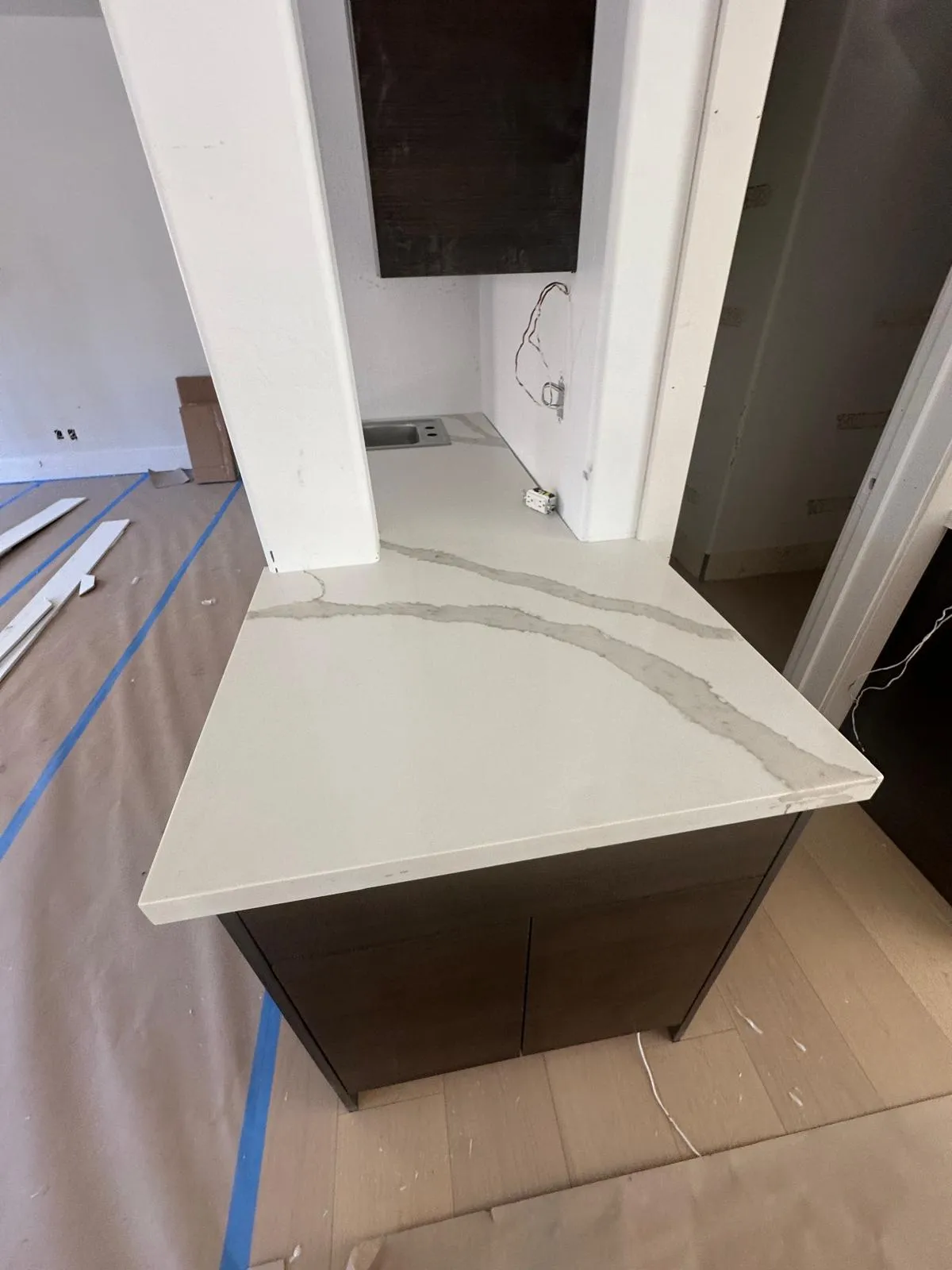 White quartz waterfall island being installed on dark cabinets by RDC Renovation in Phoenix AZ