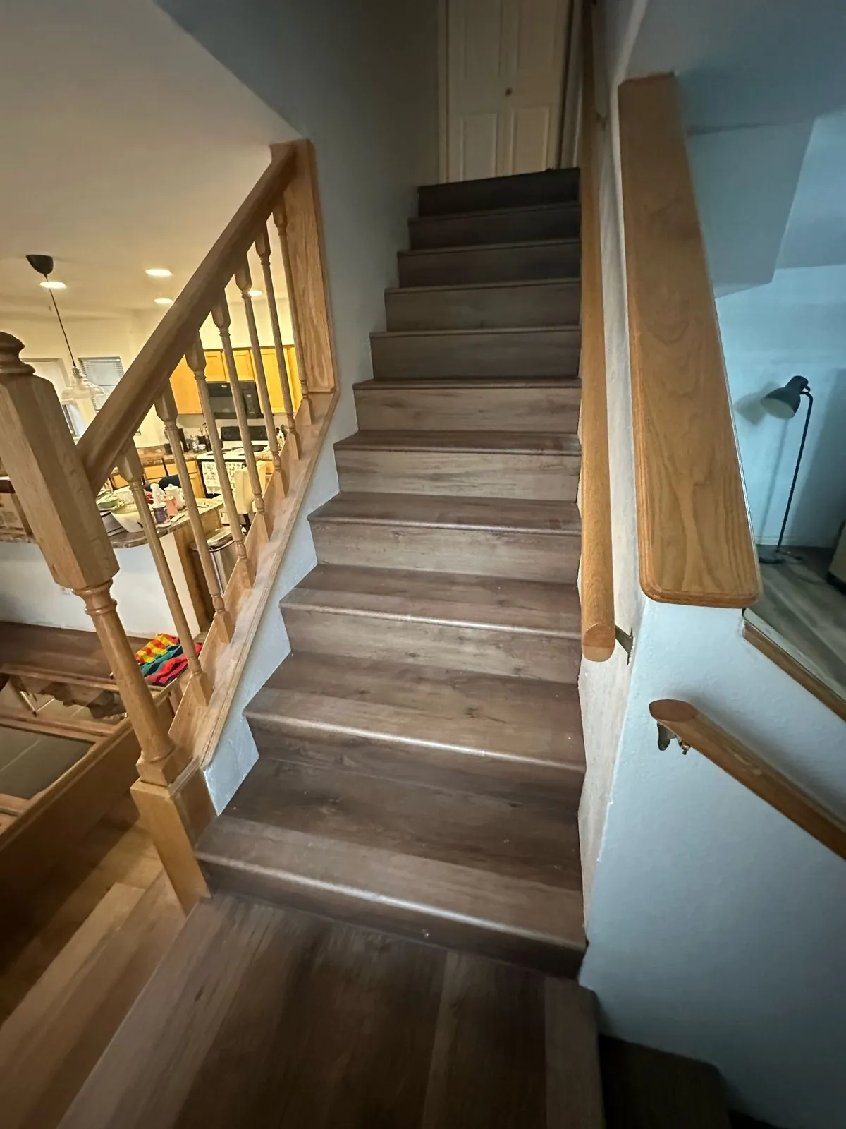 Wood look flooring installed on staircase with wood railing Phoenix AZ
